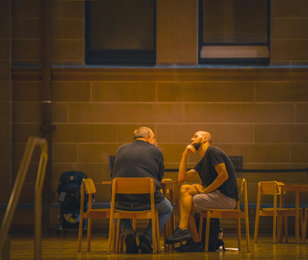 Dos personas conversando sentadas frente a frente.